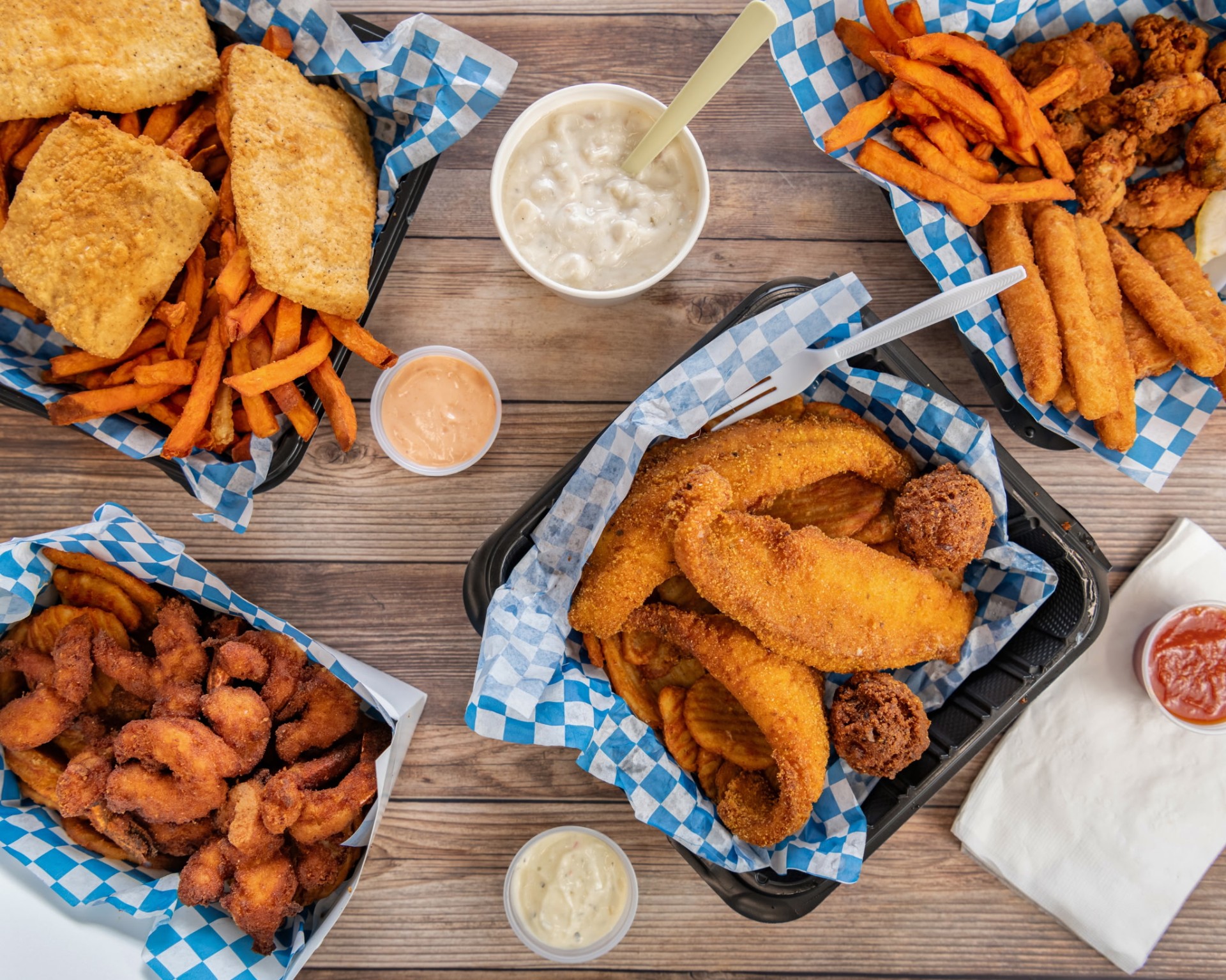 Spread of fried fish baskets, sweet potato fries, shrimp, and chowder